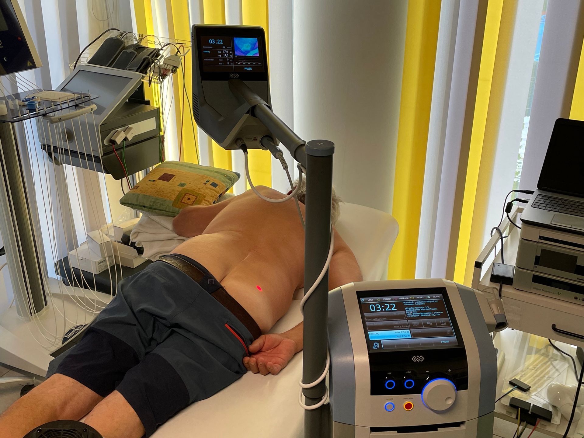 Ein Mann liegt mit einer Maschine auf seinem Rücken auf einem Bett.