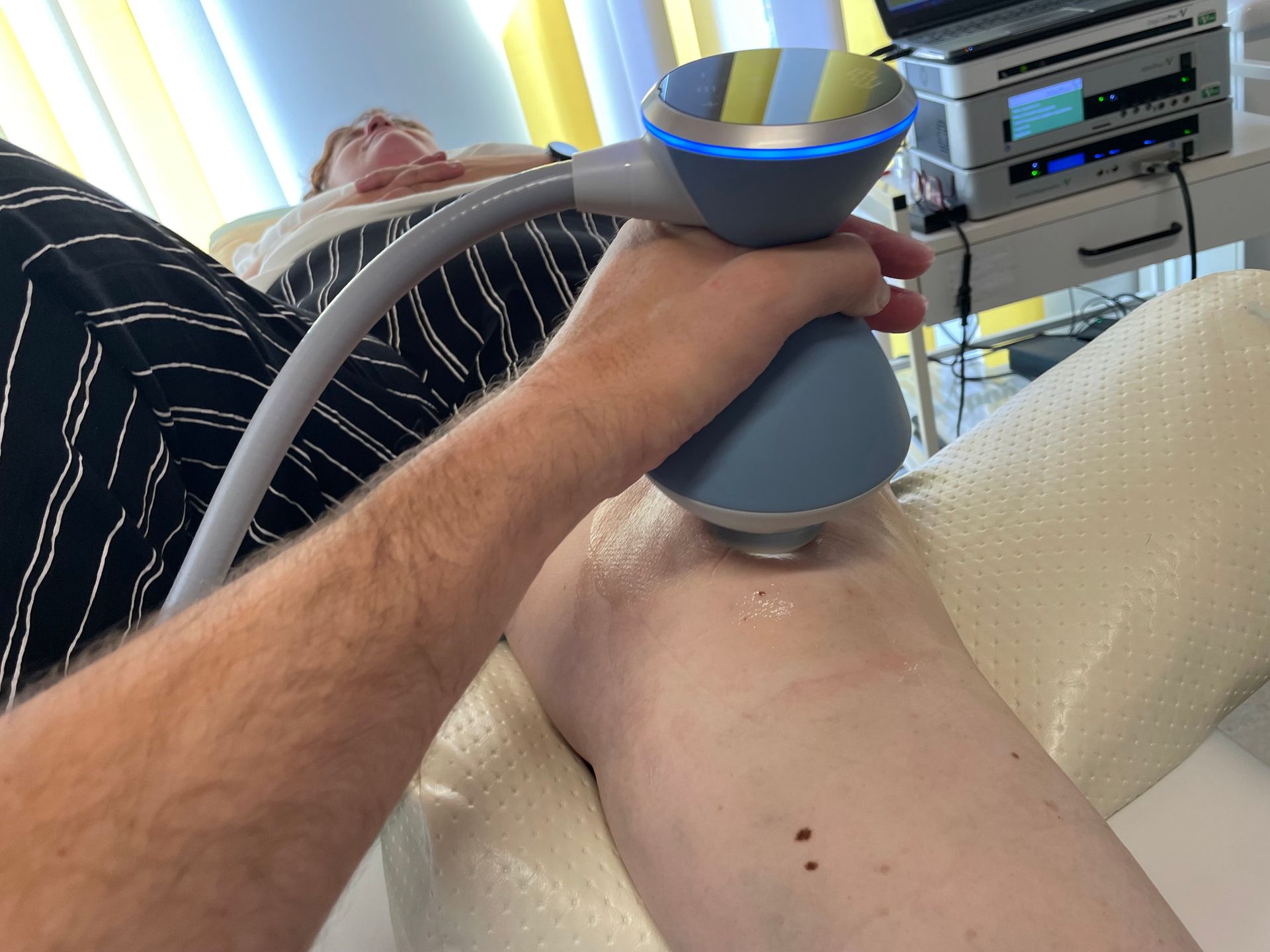 Eine Person erhält eine Beinbehandlung mit einer Maschine.