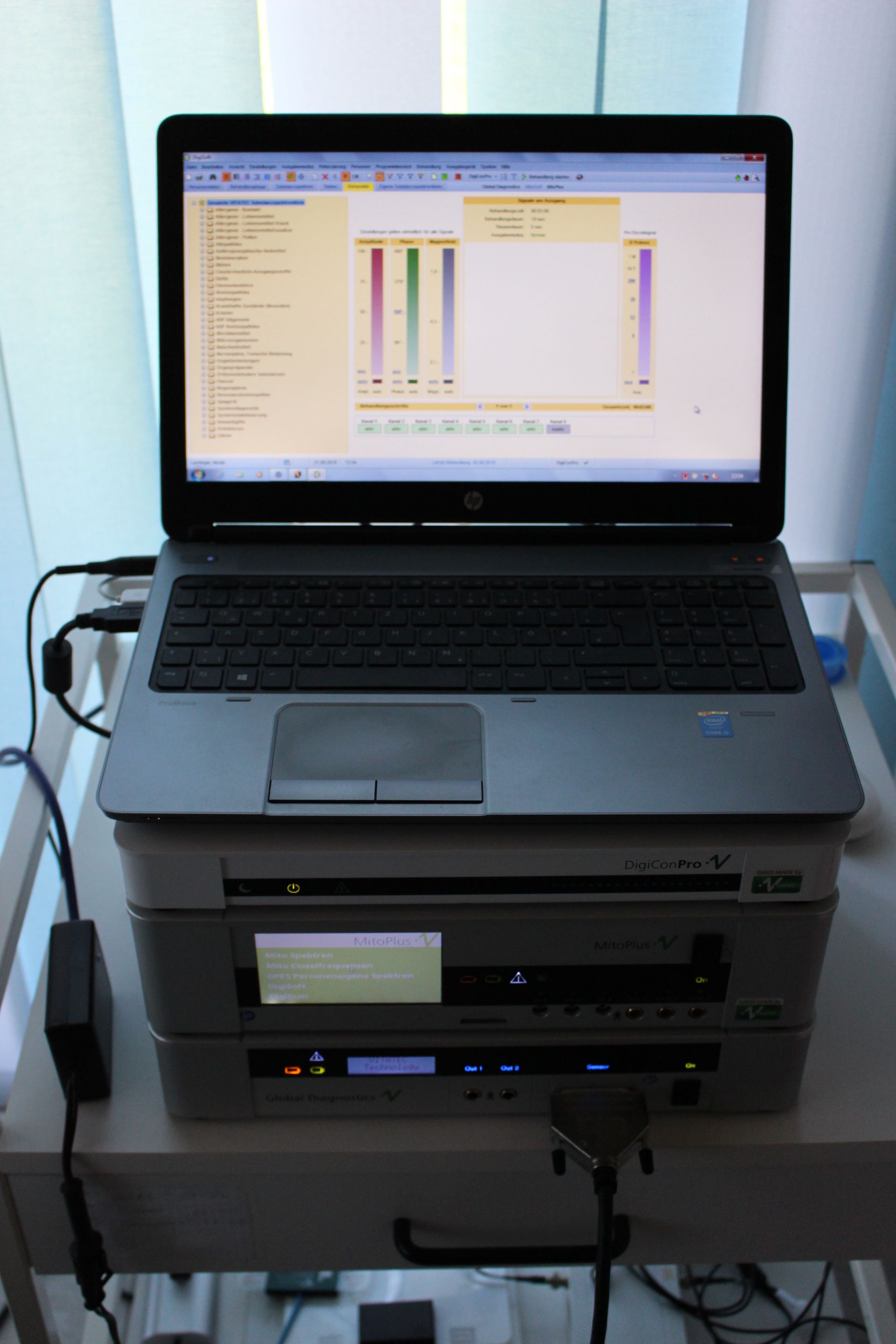 Auf einem Tisch steht ein Laptop auf einem Drucker.