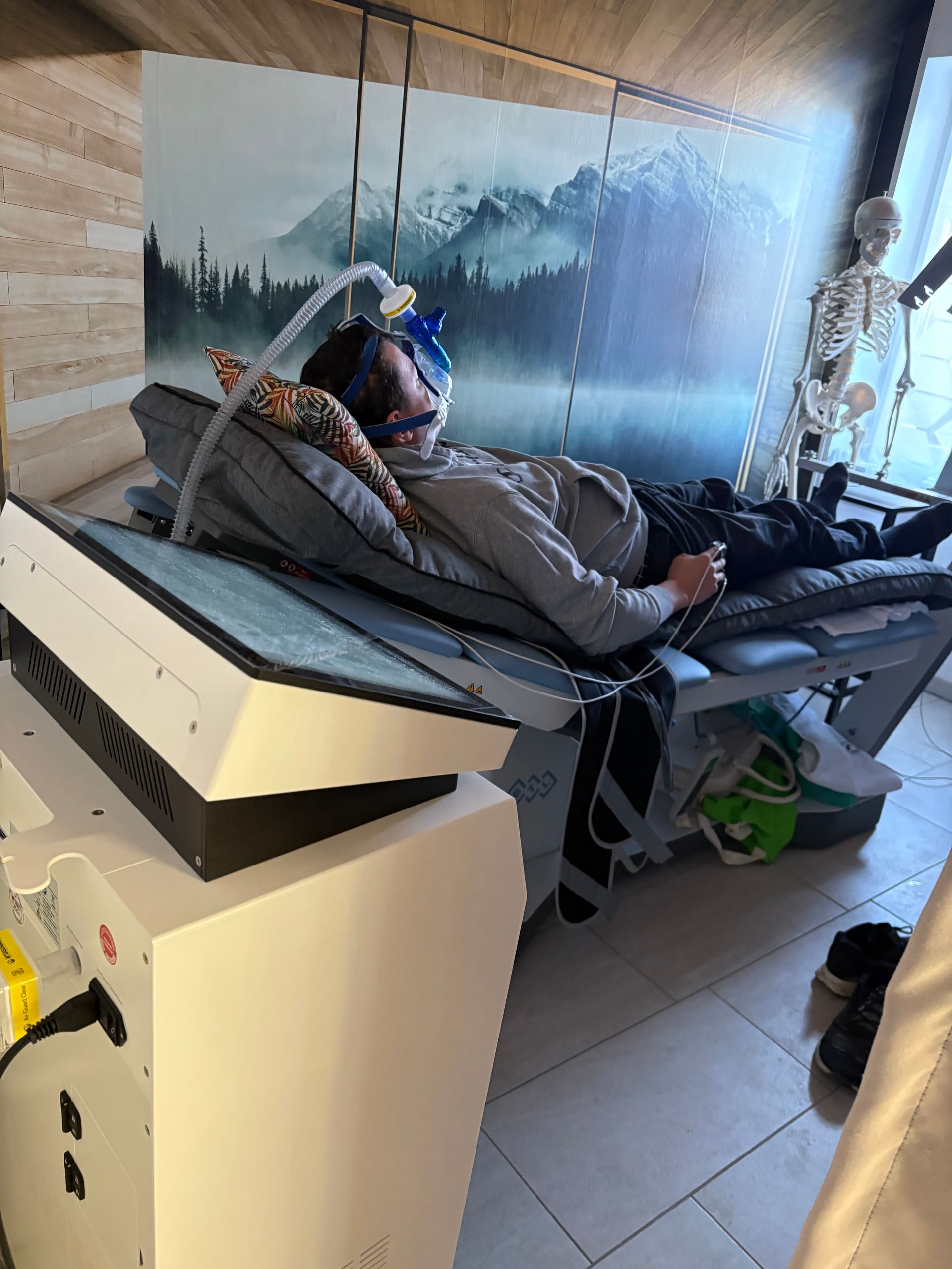 Ein Mann liegt mit einer Maske im Gesicht auf einem Bett.