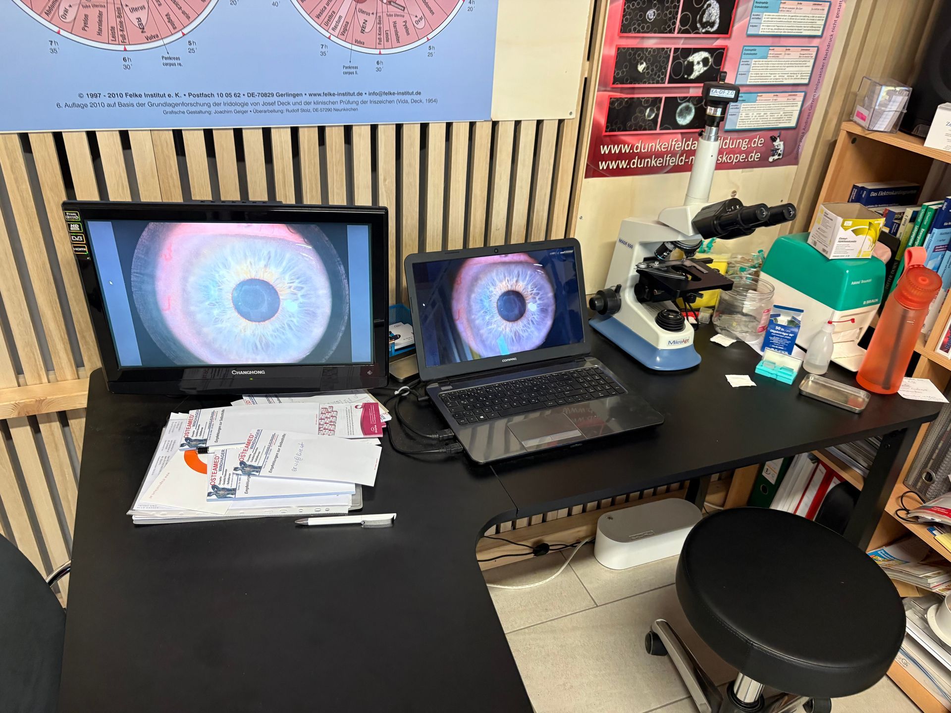Ein Schreibtisch mit zwei Laptops und einem Mikroskop darauf