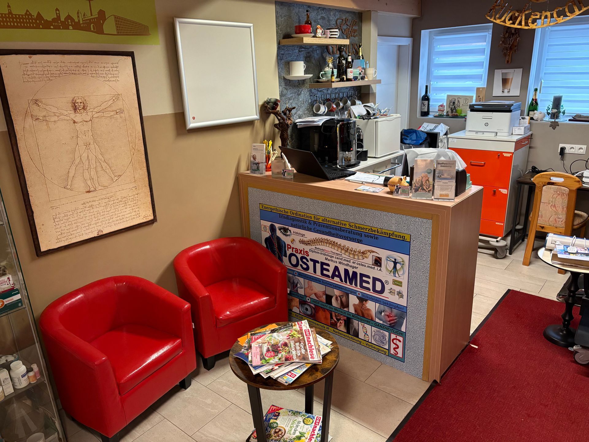 Ein Wartezimmer mit roten Stühlen und einem Schild mit der Aufschrift „Osteamed“