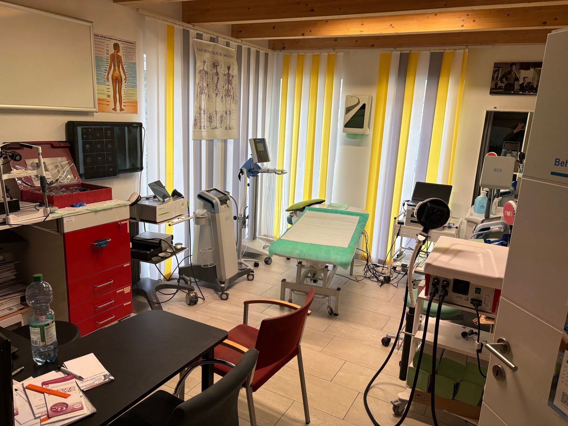 Eine Arztpraxis mit Tisch, Stühlen und anderer medizinischer Ausrüstung.