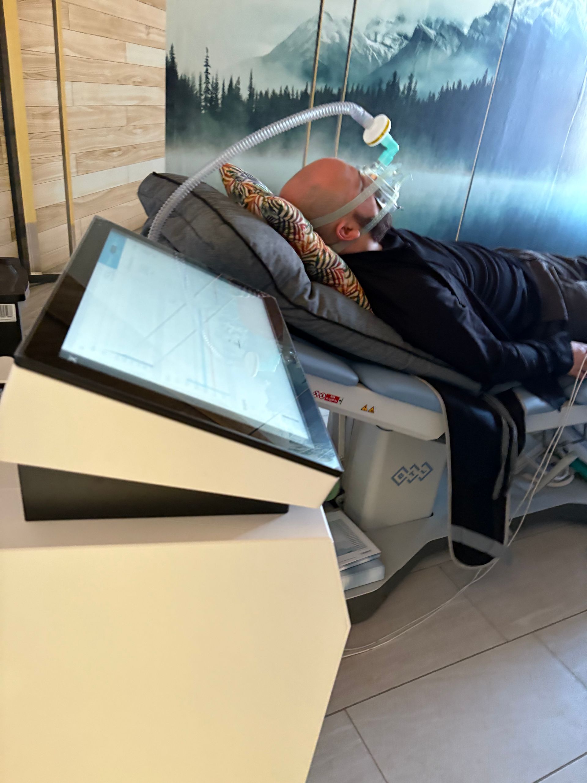Ein Mann liegt in einem Krankenhausbett mit einem Monitor an der Seite