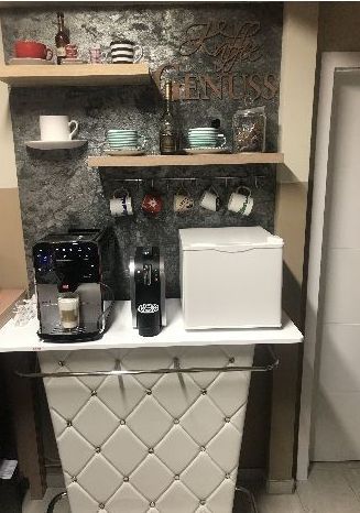 Eine Kaffeestation mit Kaffeemaschine und Kühlschrank.
