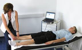 Eine Frau steht neben einem Mann, der auf einem Bett liegt.