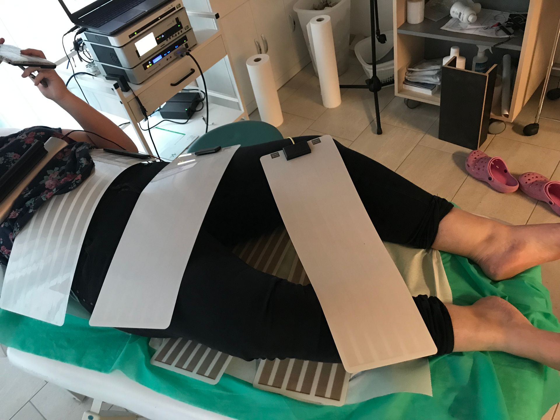 Eine Frau liegt auf einem Bett mit einem Laptop im Hintergrund