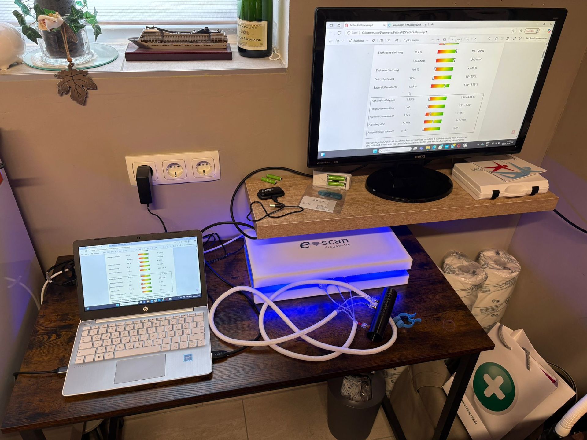 Ein Laptop und ein Computer stehen auf einem Holzschreibtisch.