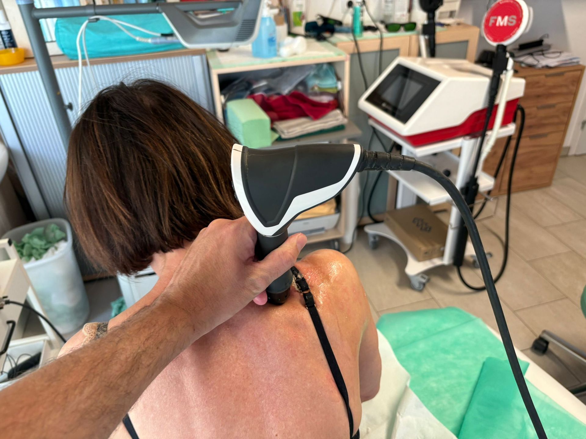 Eine Frau bekommt mit einem Gerät eine Rückenmassage.