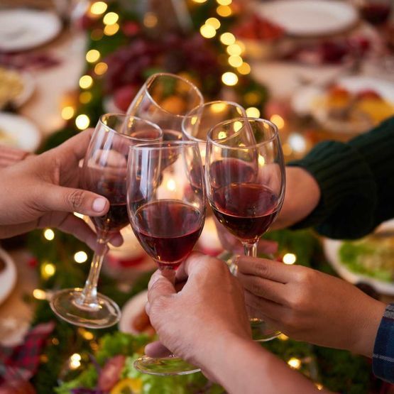 Un grupo de personas están brindando con copas de vino.