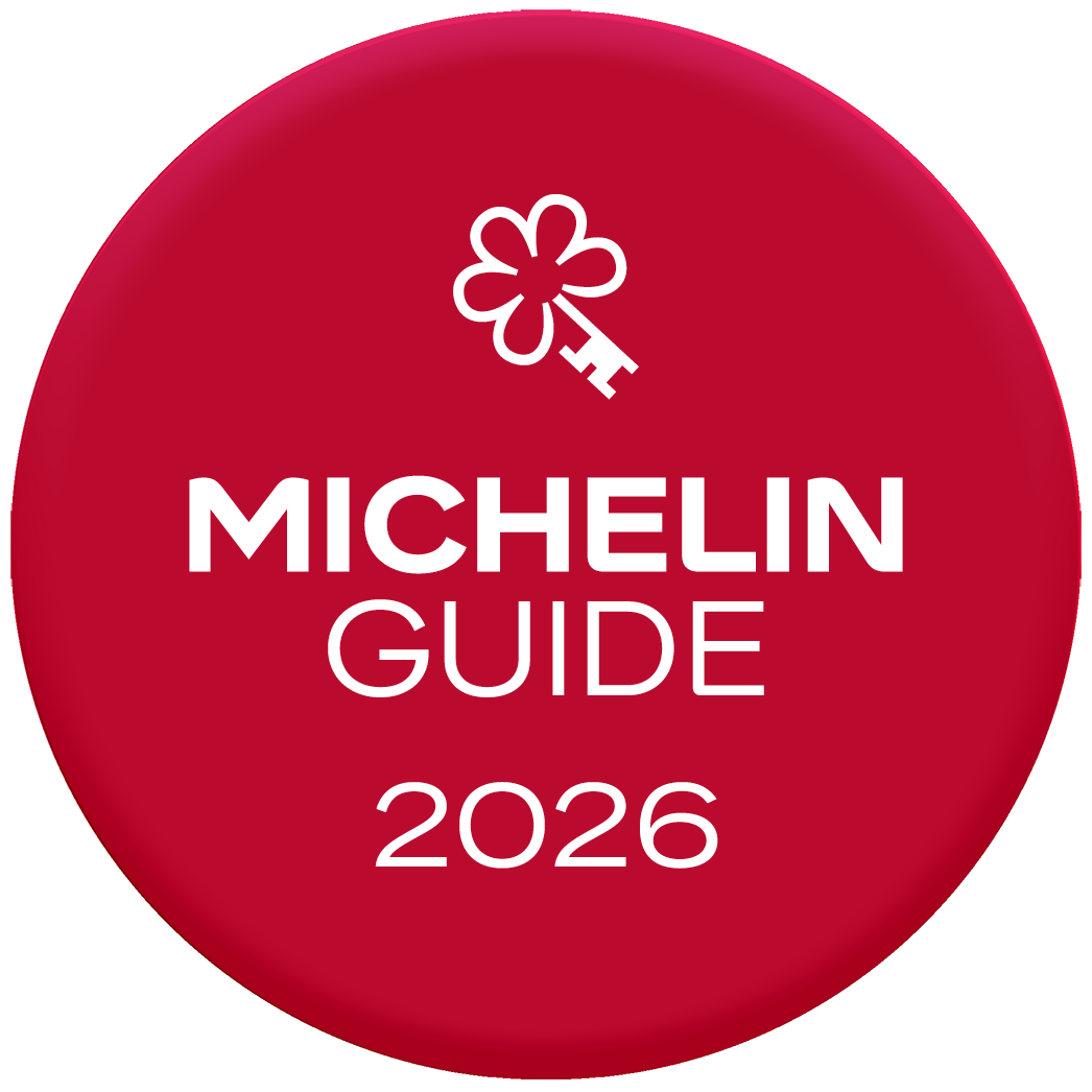 Een rood, rond logo met een wit Michelin-sleutelsymbool boven de tekst