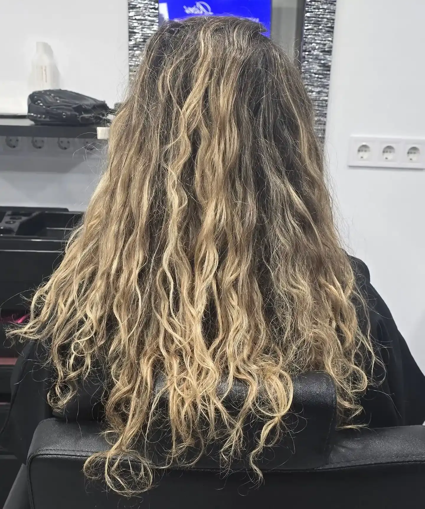 Cabello largo, ondulado y con múltiples tonalidades de castaño y rubio, visto 