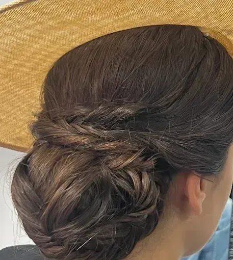Primer plano de un recogido de cabello castaño oscuro con una sección trenzada 