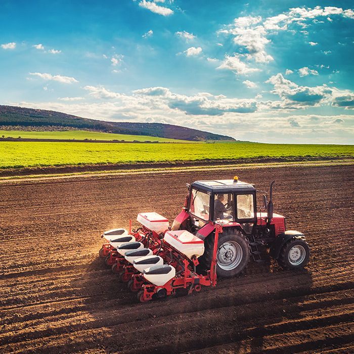 Punainen traktori kylvökoneella, vaihtonkoneen