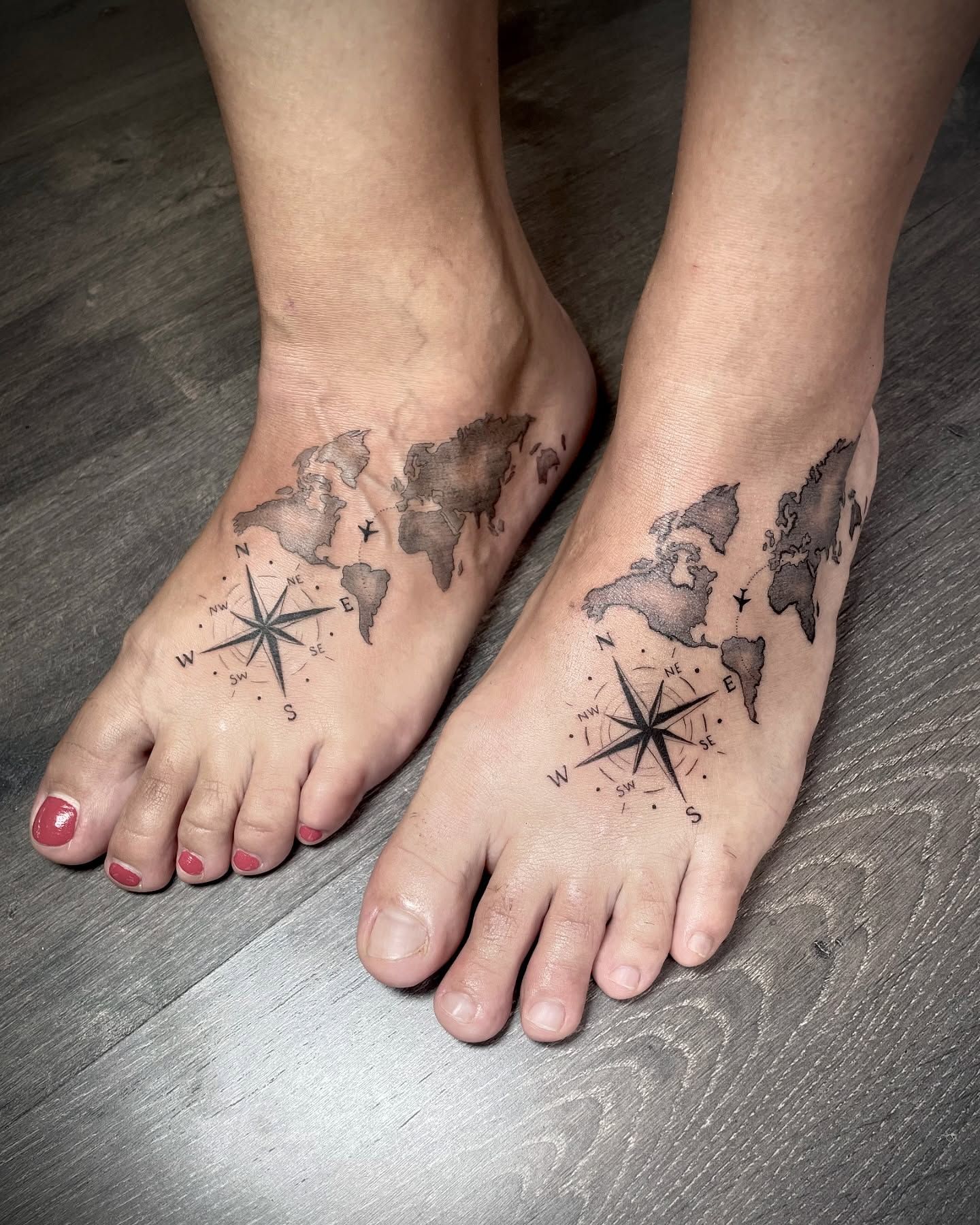 Un par de pies con un mapa y una brújula tatuados en ellos.