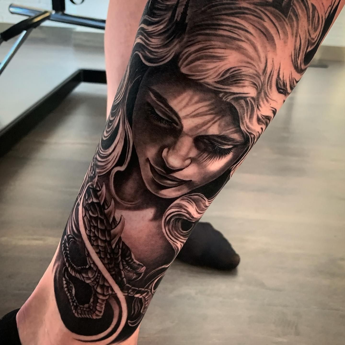 Una persona tiene un tatuaje de la cara de una mujer en su pierna.