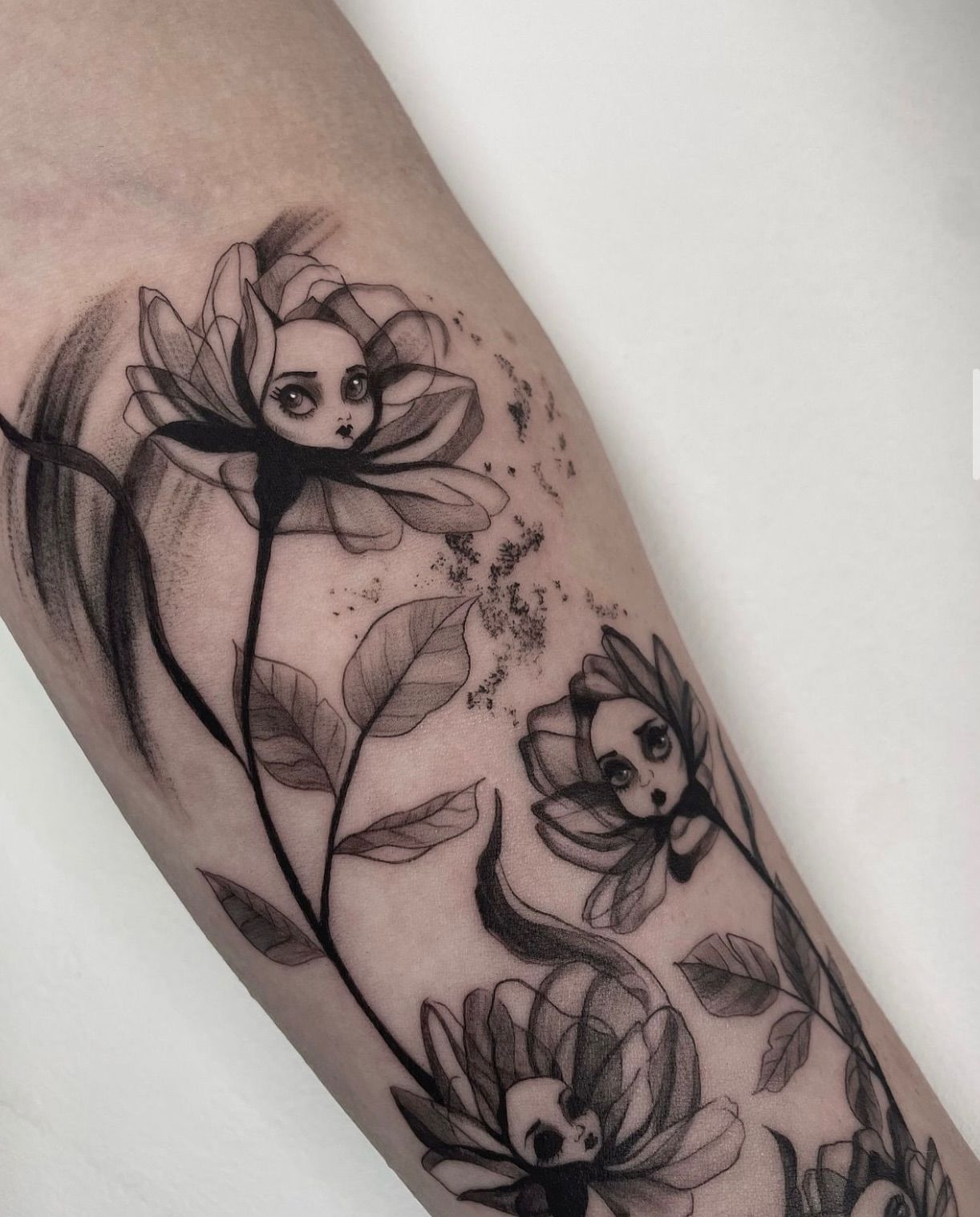 Un tatuaje en blanco y negro de flores en el brazo de una persona.