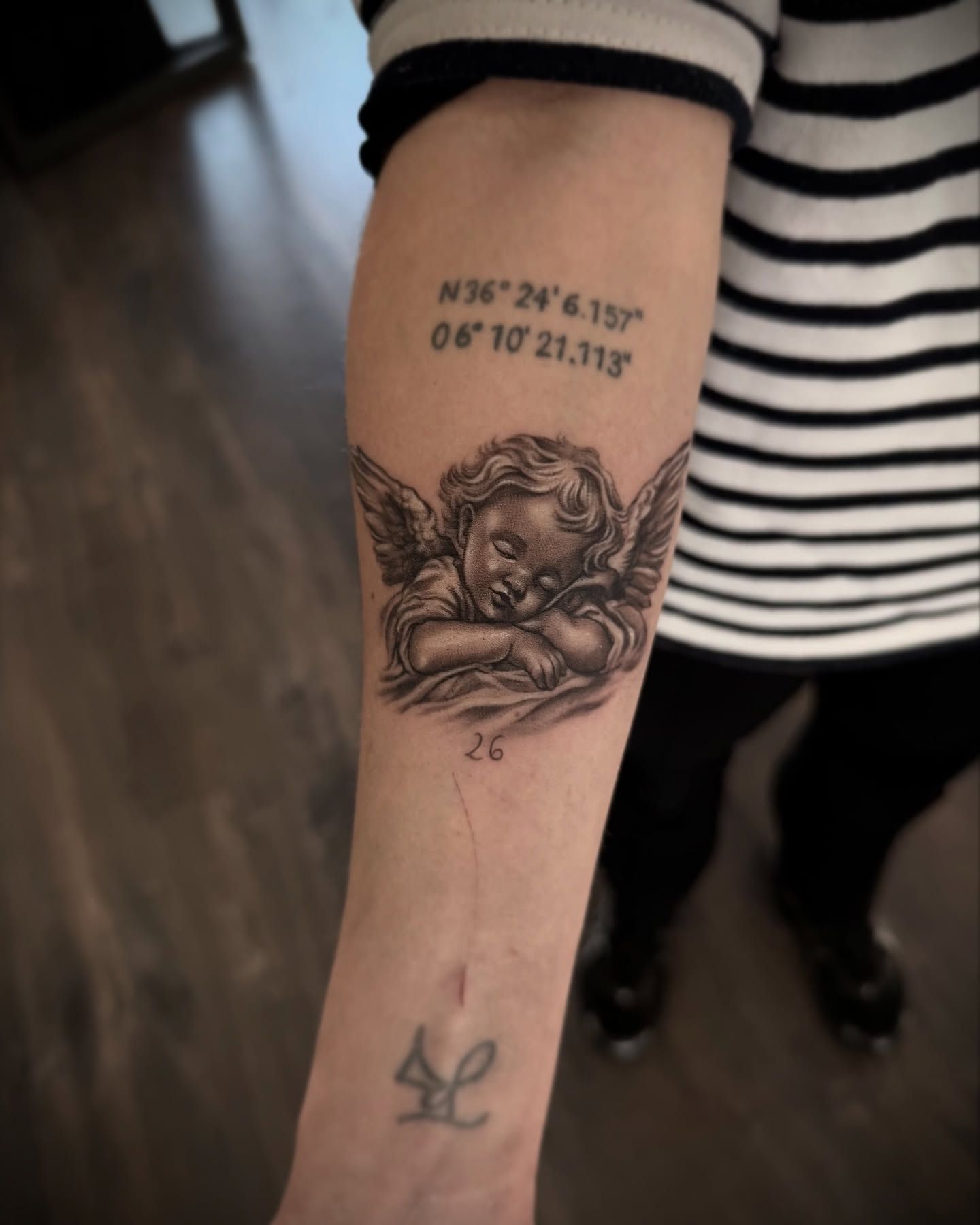 Una mujer tiene un tatuaje de un ángel en su antebrazo.