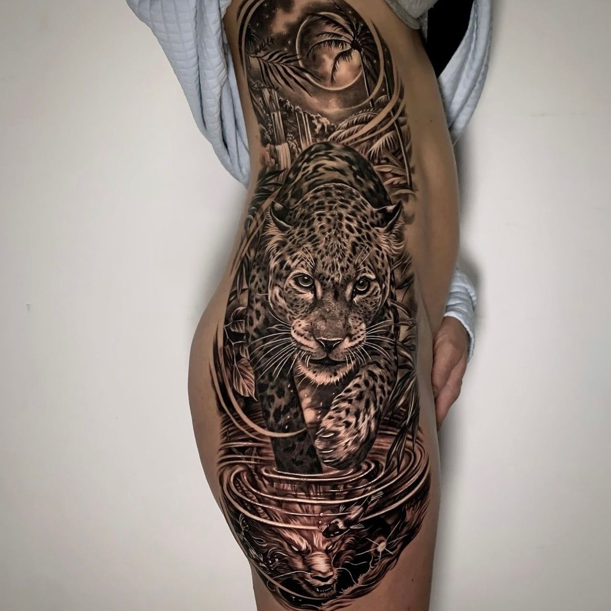 Una mujer tiene un tatuaje de un leopardo en su costado.