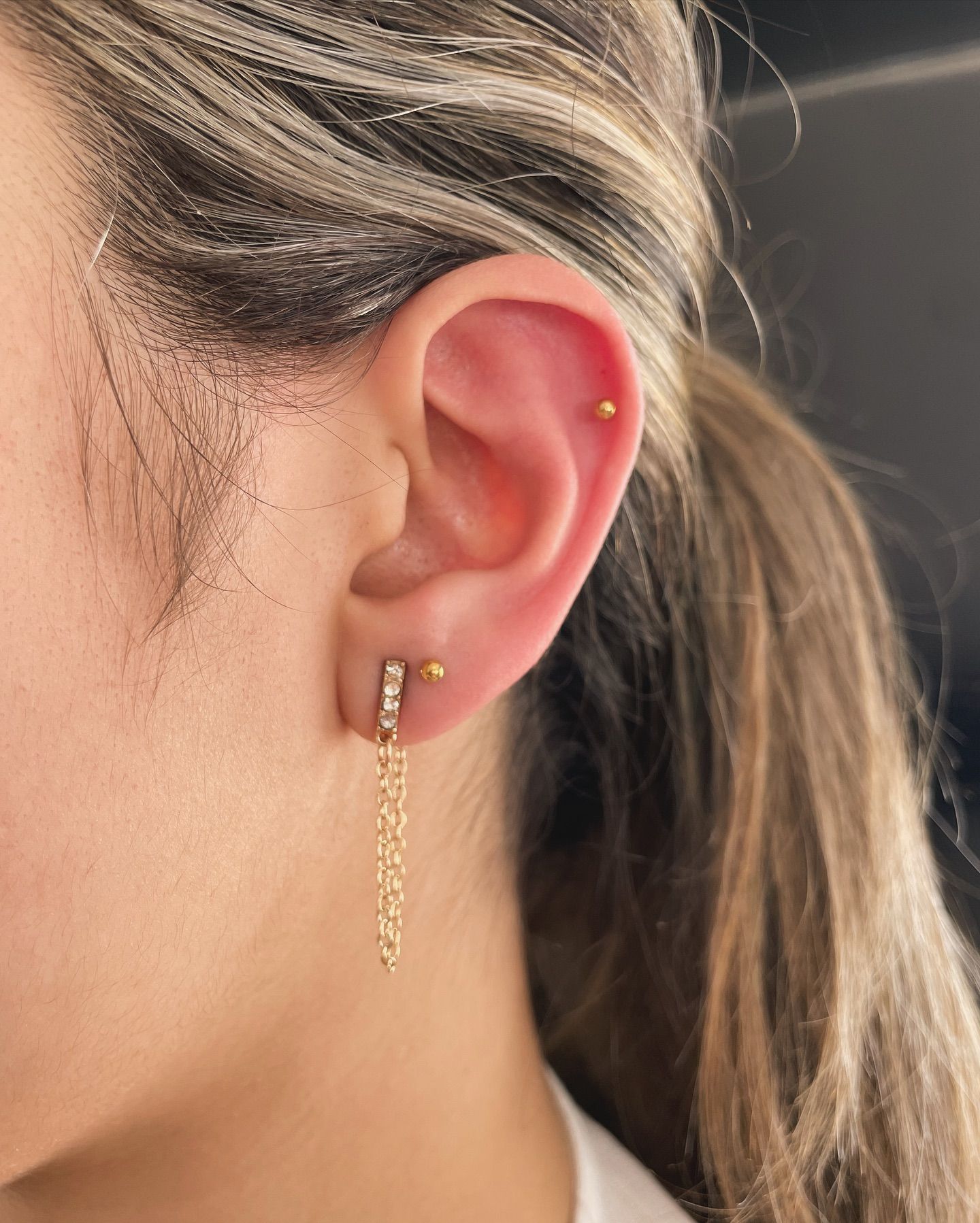 Un primer plano de la oreja de una mujer con pendientes.