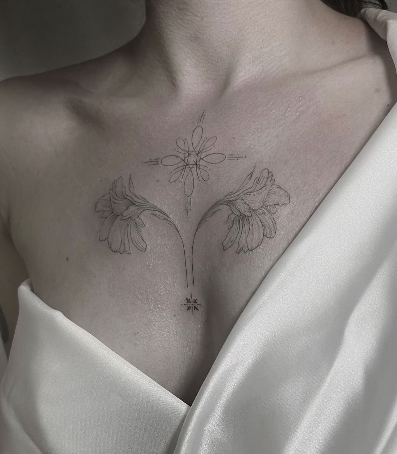Una mujer tiene un tatuaje de dos flores en el pecho.