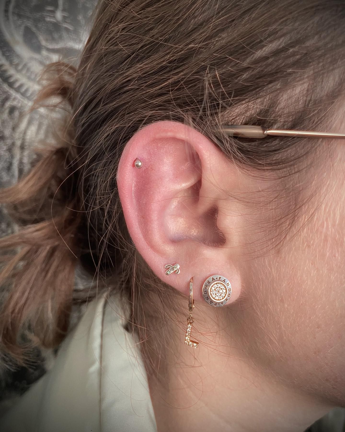 Un primer plano de la oreja de una mujer con múltiples perforaciones.