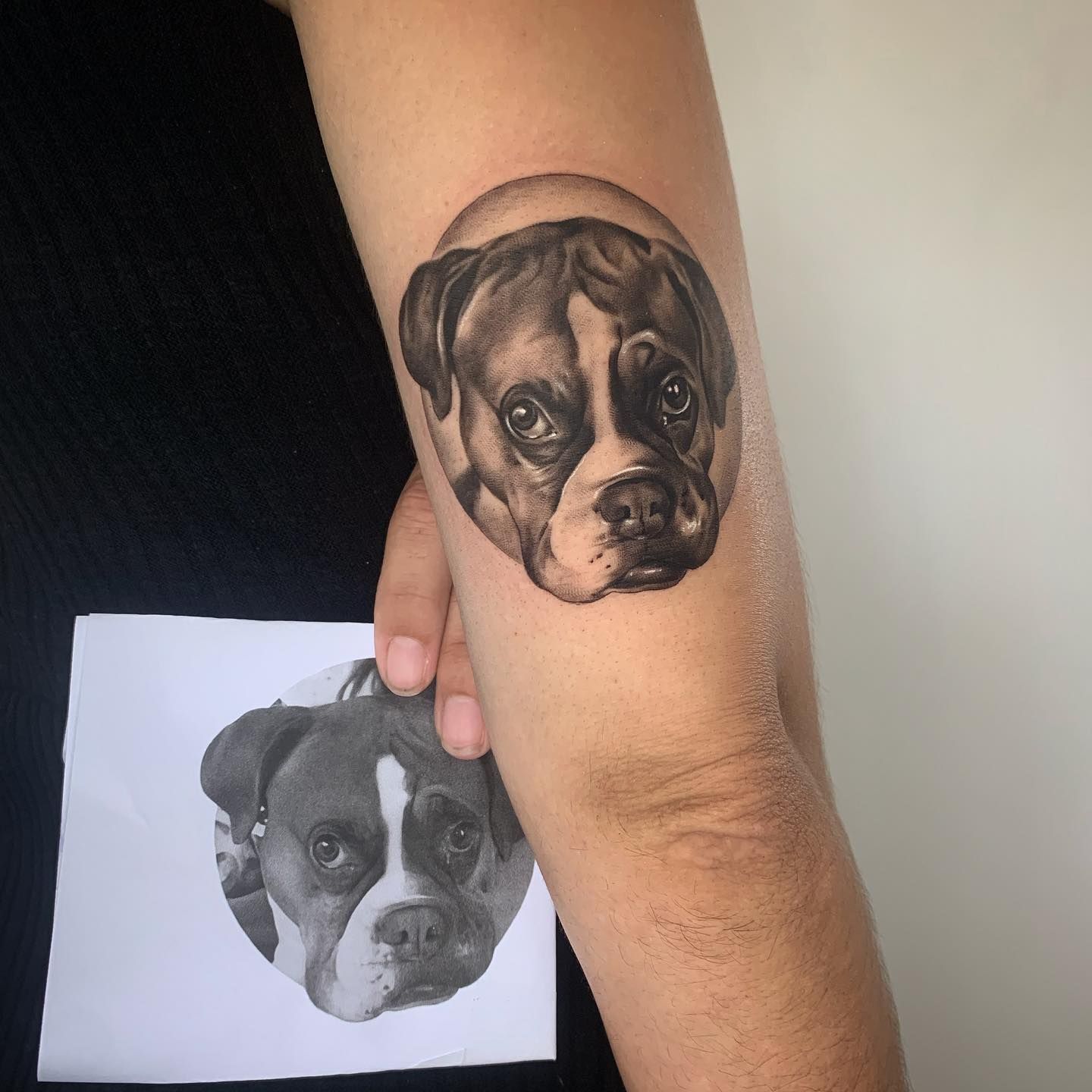 Una persona tiene un tatuaje de un perro en el brazo.