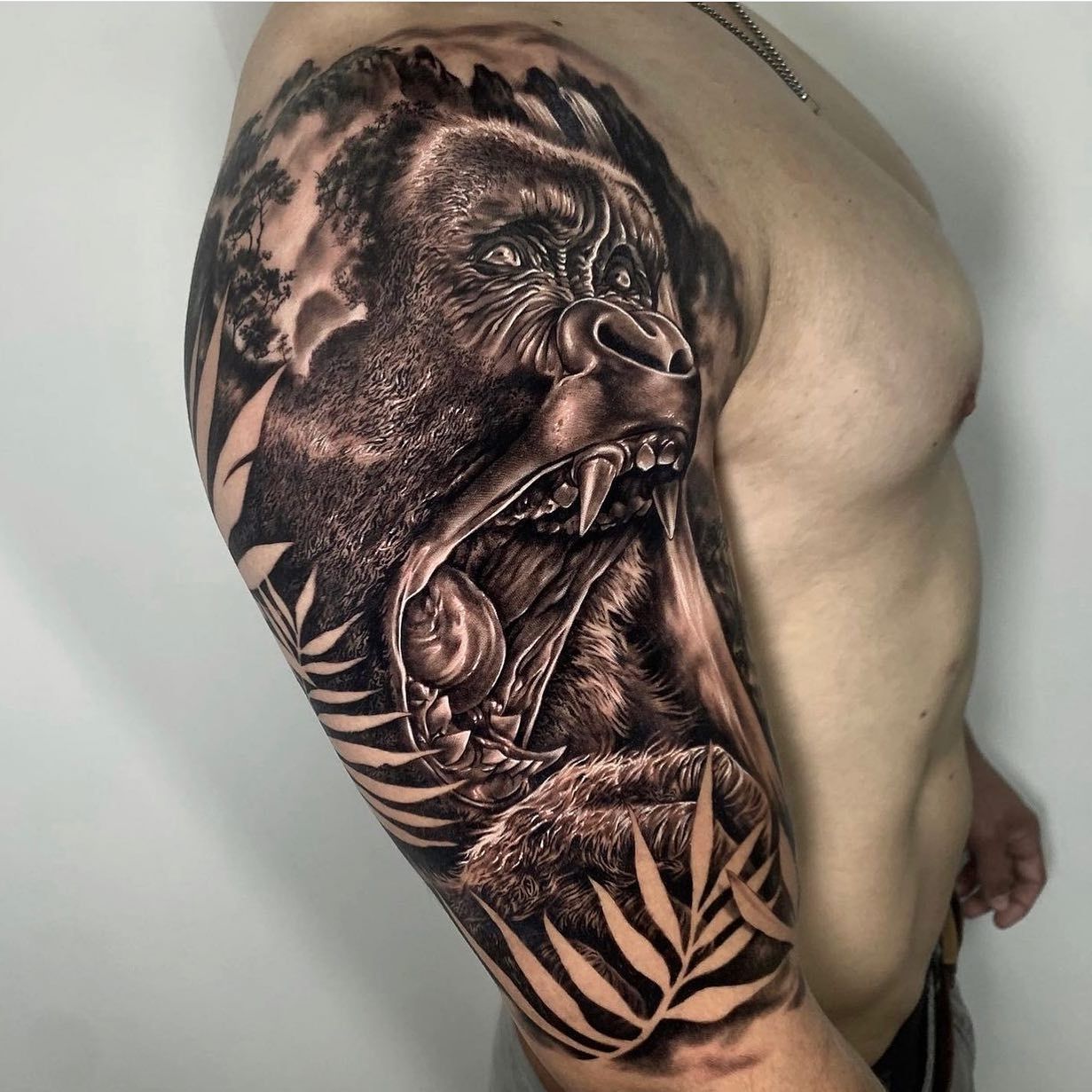 Un hombre tiene un tatuaje de un gorila en su brazo.