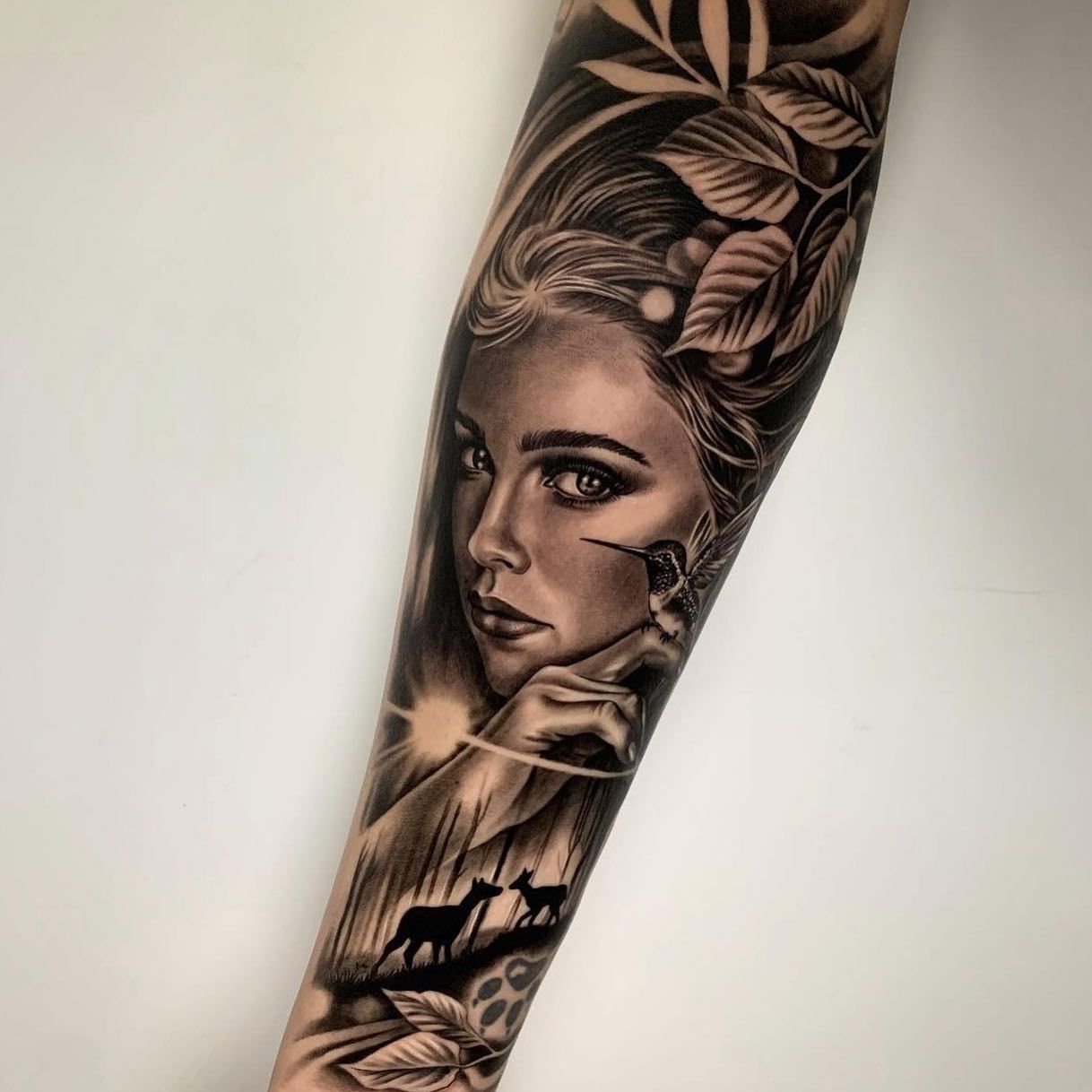 Un tatuaje en blanco y negro del rostro de una mujer en un antebrazo.