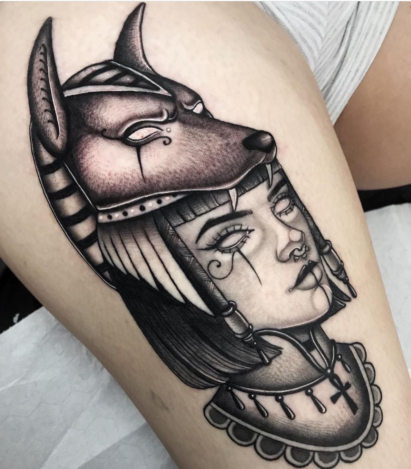 Un tatuaje en blanco y negro de una mujer con una máscara.