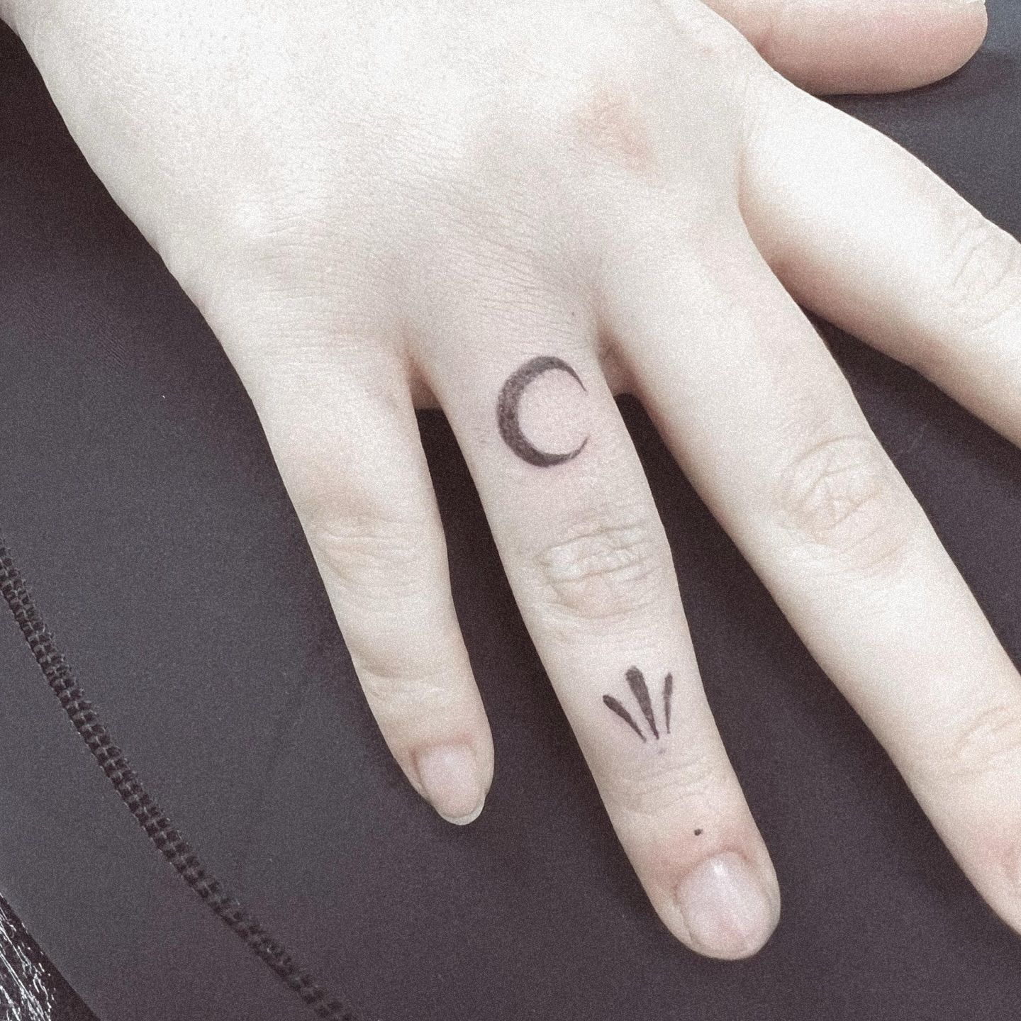 Un primer plano de la mano de una persona con un tatuaje en el pulgar.