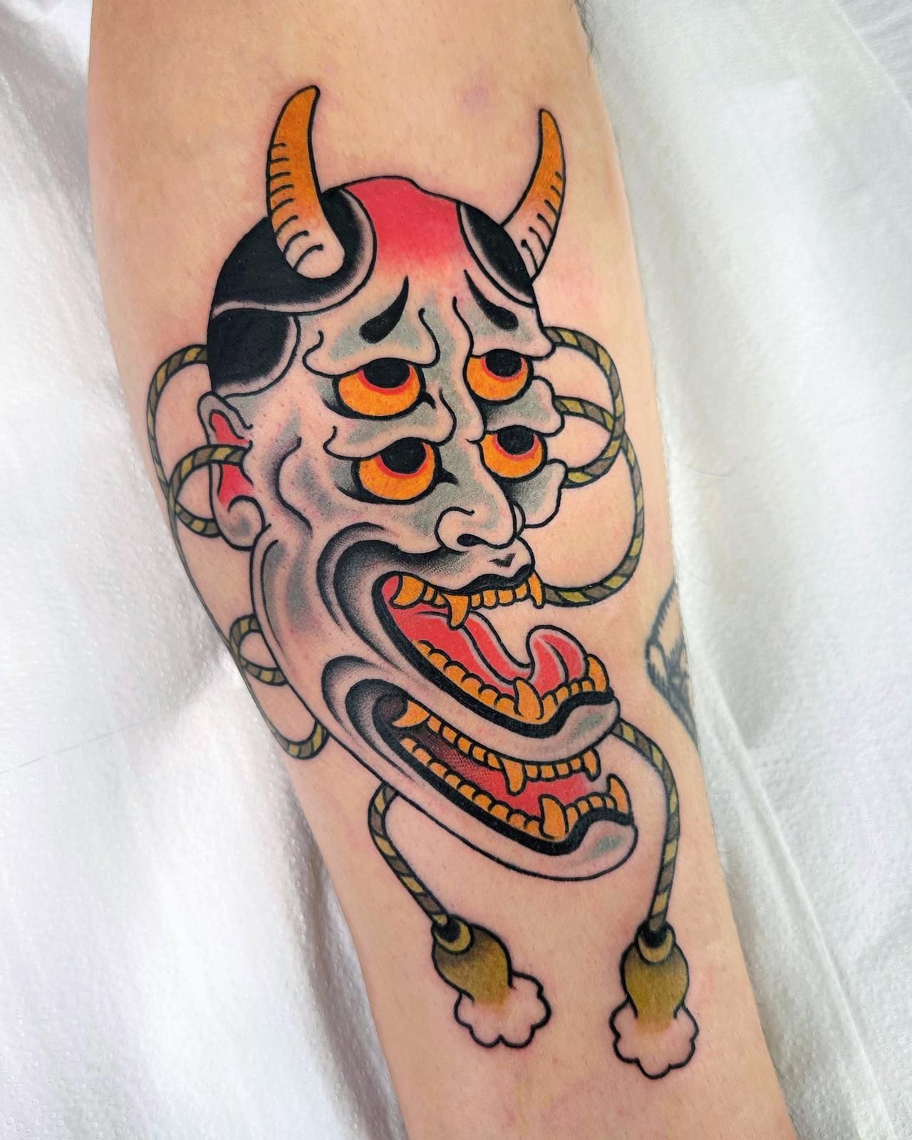 Una persona tiene un tatuaje de un demonio con cuernos en el brazo.