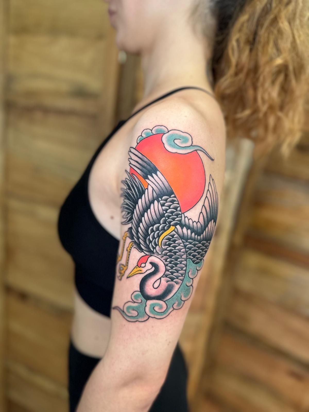 Una mujer tiene un tatuaje de un pájaro en su brazo.