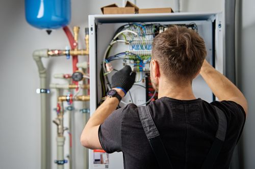 Une personne réparant une pompe à chaleur.