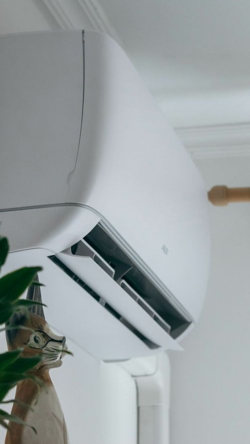 Une climatisation accrochée sur un mur blanc.