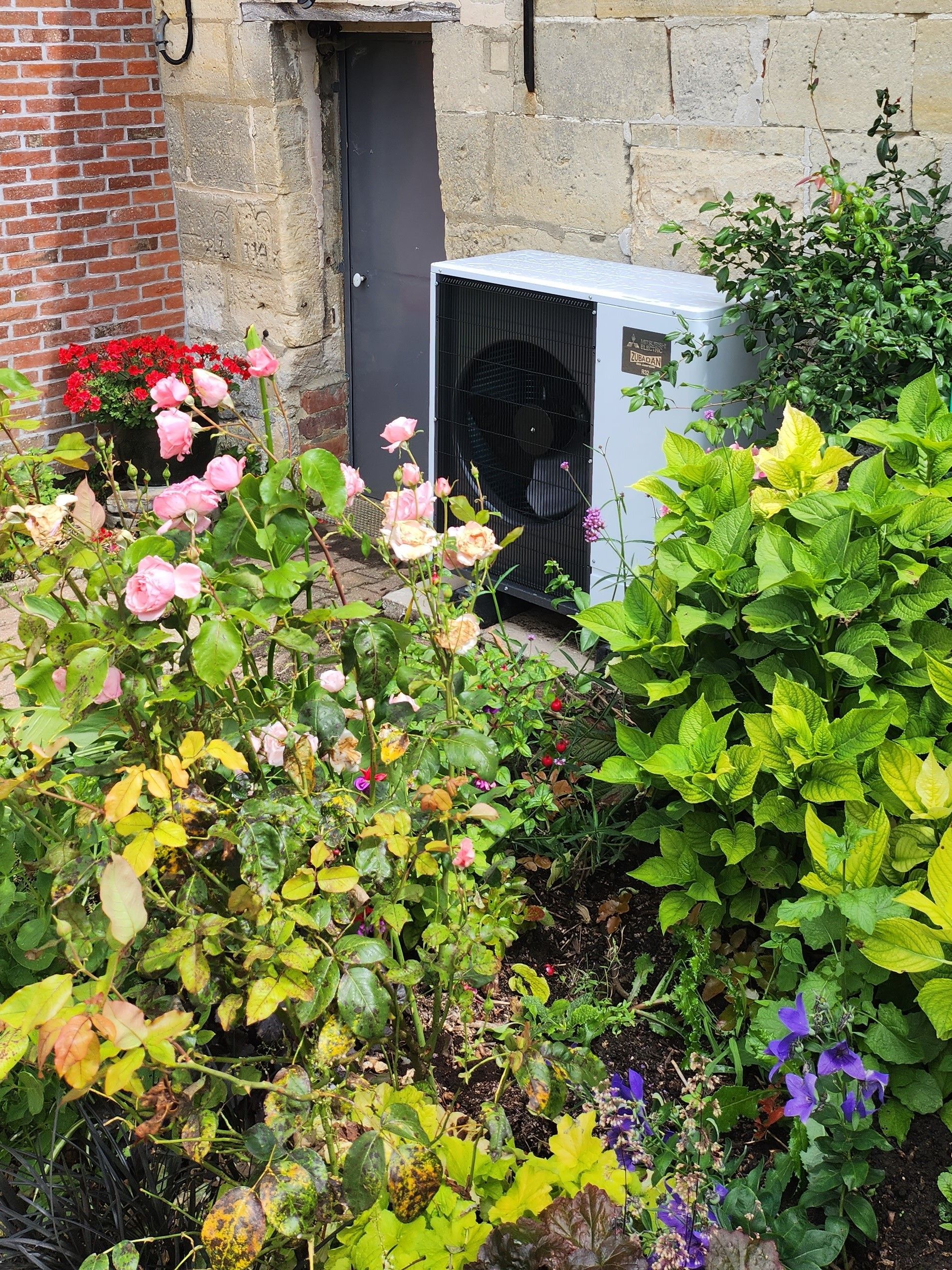 Une unité de pompe à chaleur dans un jardin.