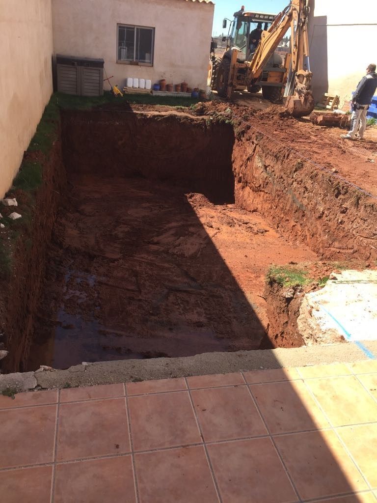 Una excavadora grande está cavando un hoyo en el suelo.