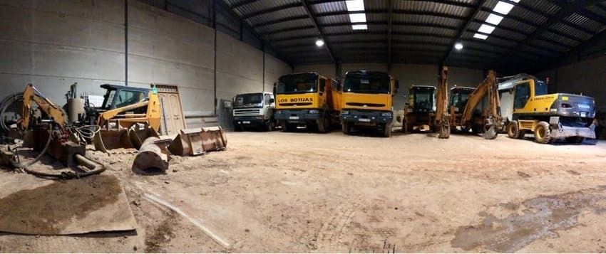 Un gran almacén lleno de muchos vehículos de construcción.