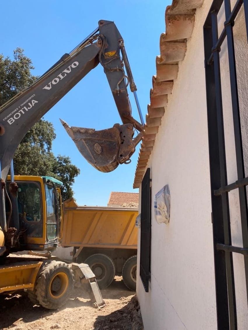 Una excavadora Volvo está cargando tierra en un camión volquete.