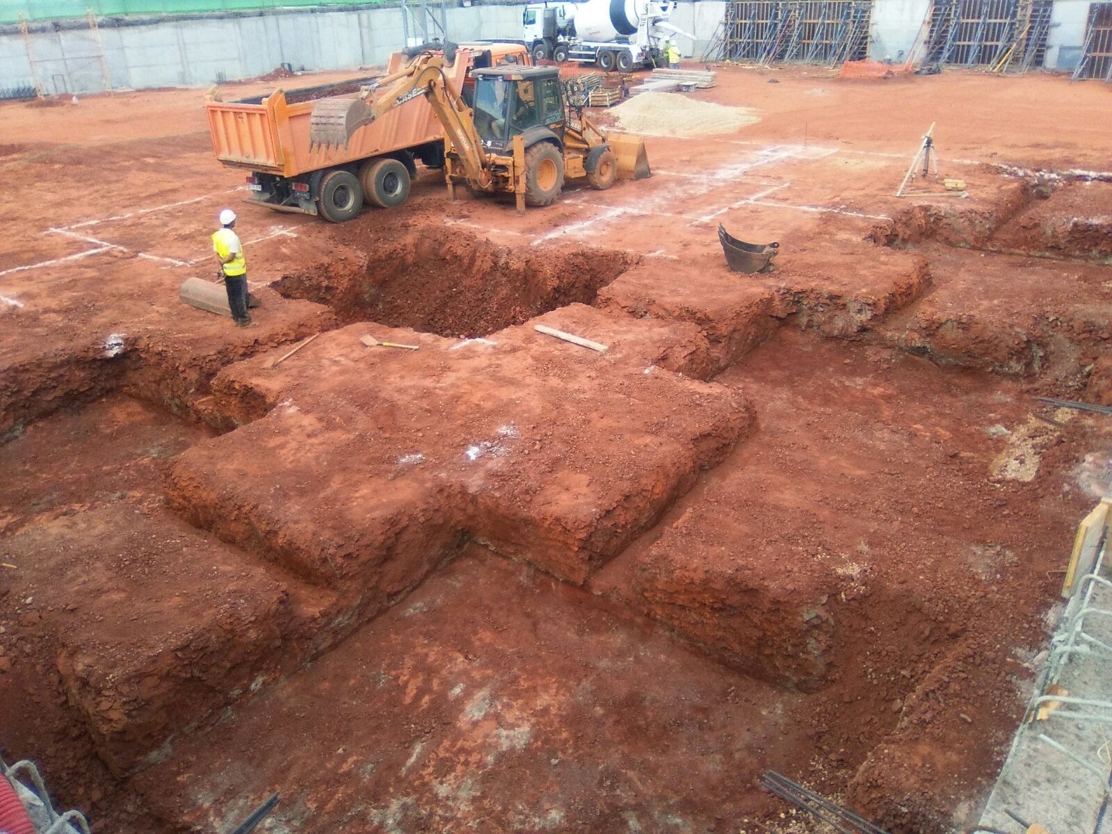 Un sitio de construcción con un camión volquete y una excavadora