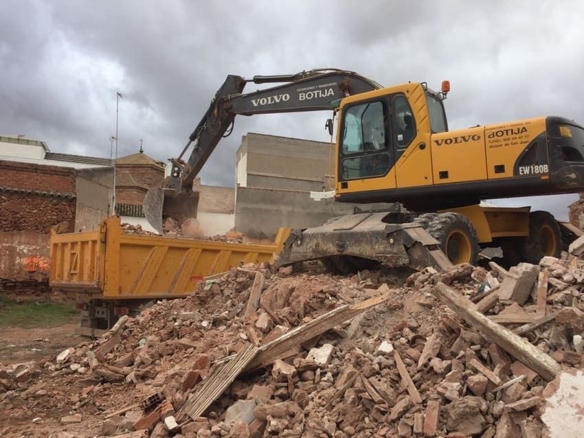 Una excavadora Volvo está trabajando en una pila de escombros.