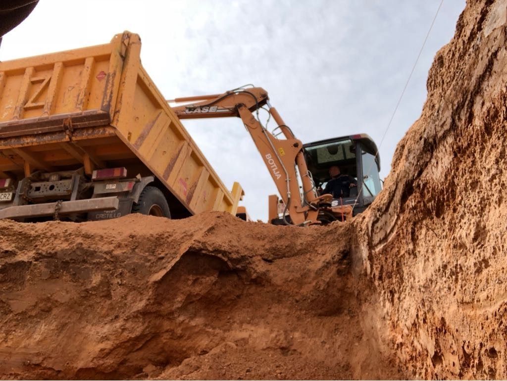 Un camión volquete amarillo se está cargando con tierra