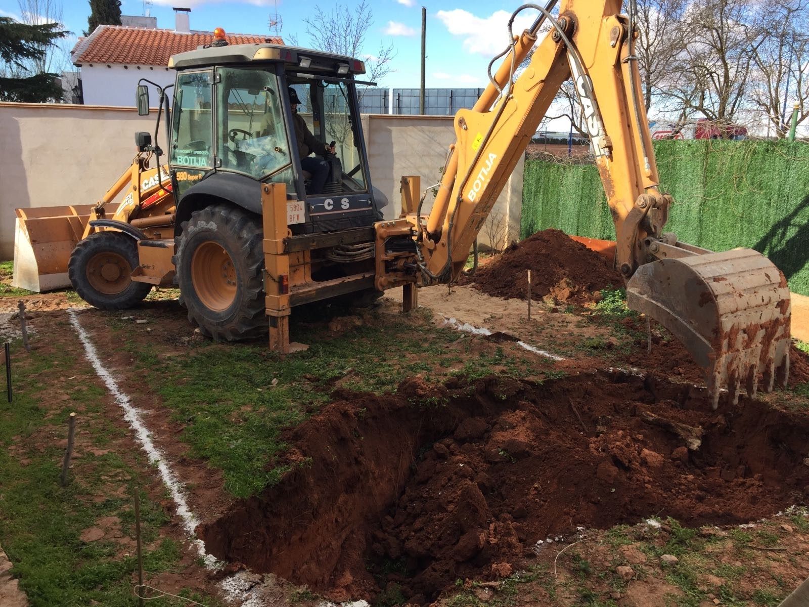 Una retroexcavadora está cavando un hoyo en el suelo