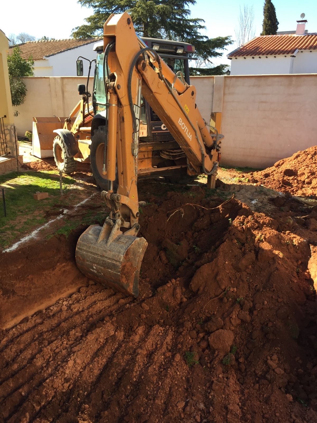 Una excavadora amarilla está cavando un hoyo en la tierra.