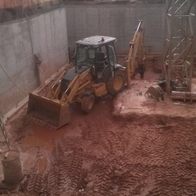 Un tractor amarillo está estacionado en una zona fangosa
