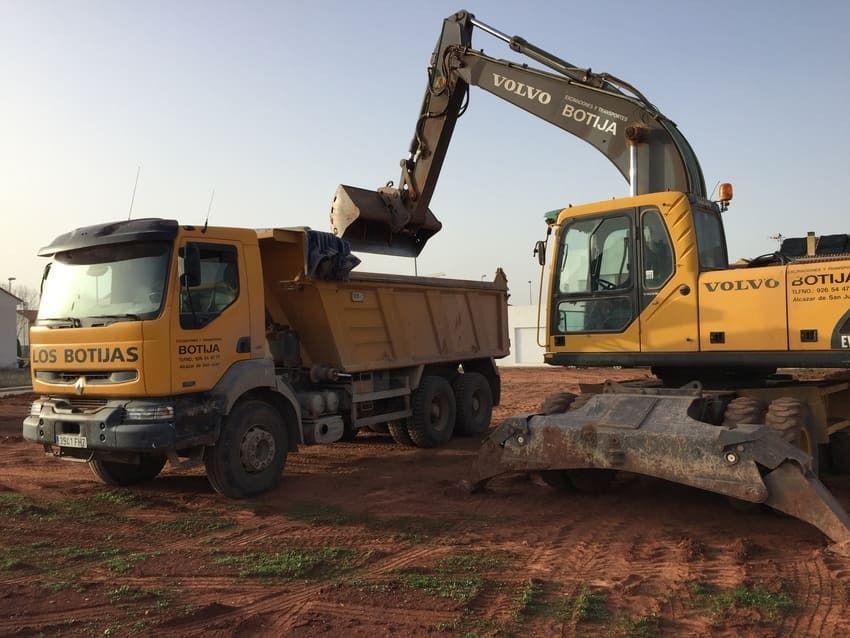 Una excavadora Volvo está cargando tierra en un camión volquete.