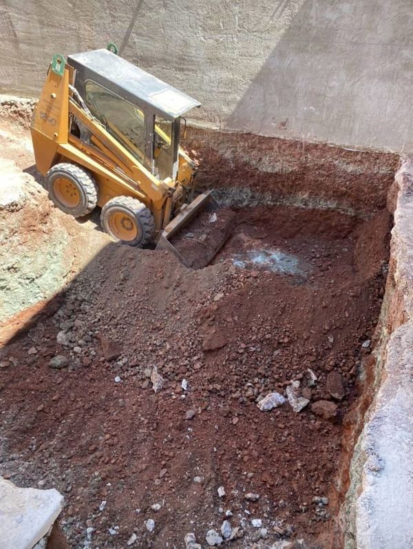 Una excavadora amarilla está cavando un hoyo en la tierra