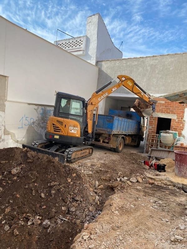 Una excavadora está cargando tierra en un camión volquete.