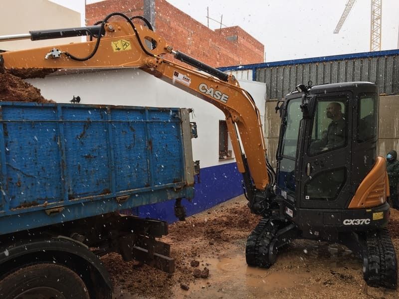 Una excavadora está cargando tierra en un camión volquete