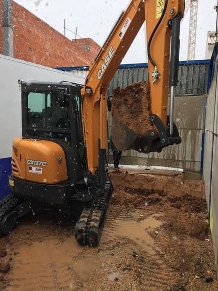 Una excavadora está cavando un hoyo en el suelo.